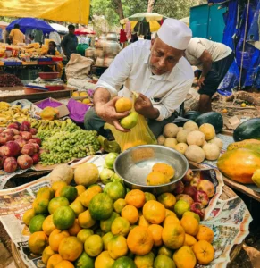 a man in a white shirt and white hat selling fruits in an open market